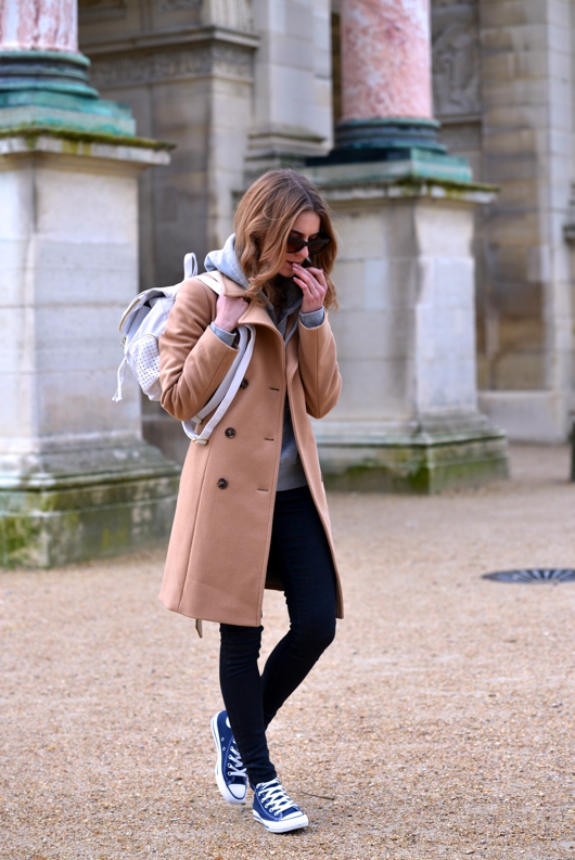 A camel coloured coat and black skinny jeans go wonderfully with a pair of navy converse. Via Katarzyna Tusk. Trousers: Moto by Topshop, Hoodie: Abercrombie & Fitch, Coat: Sisley, Shoes: Converse. 