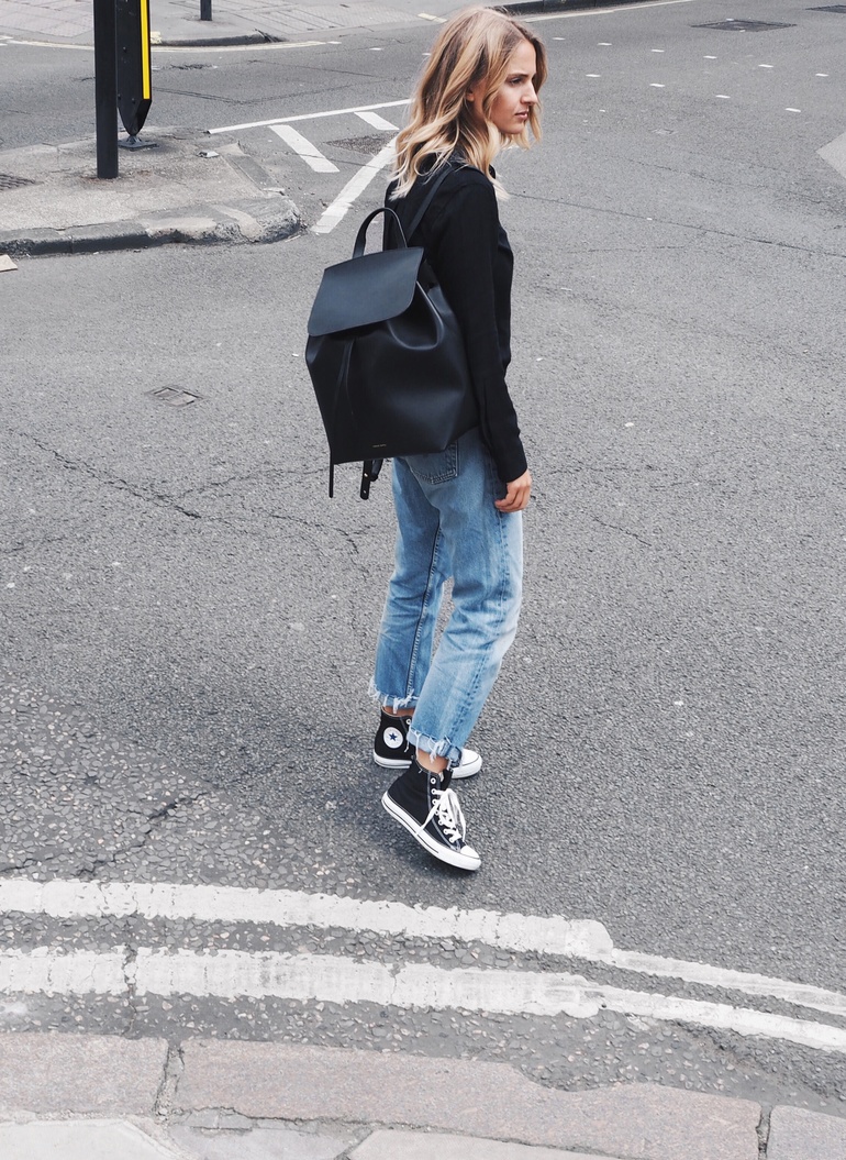 Ankle high converse look edgy and sleek when worn with ripped mom jeans and a casual black shirt. Via Mirjam Flatau. Jeans: Levi, Shoes: Converse, Shirt: Rails